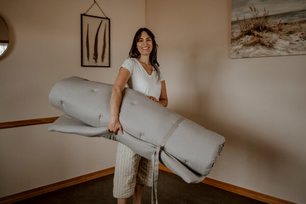 Salvia holding a Thai mat to show size of 80" x 60"